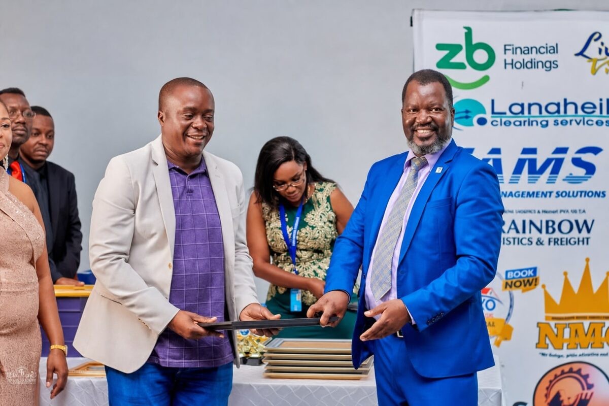Benson Mukandiwa presenting a framed recognition at a corporate event