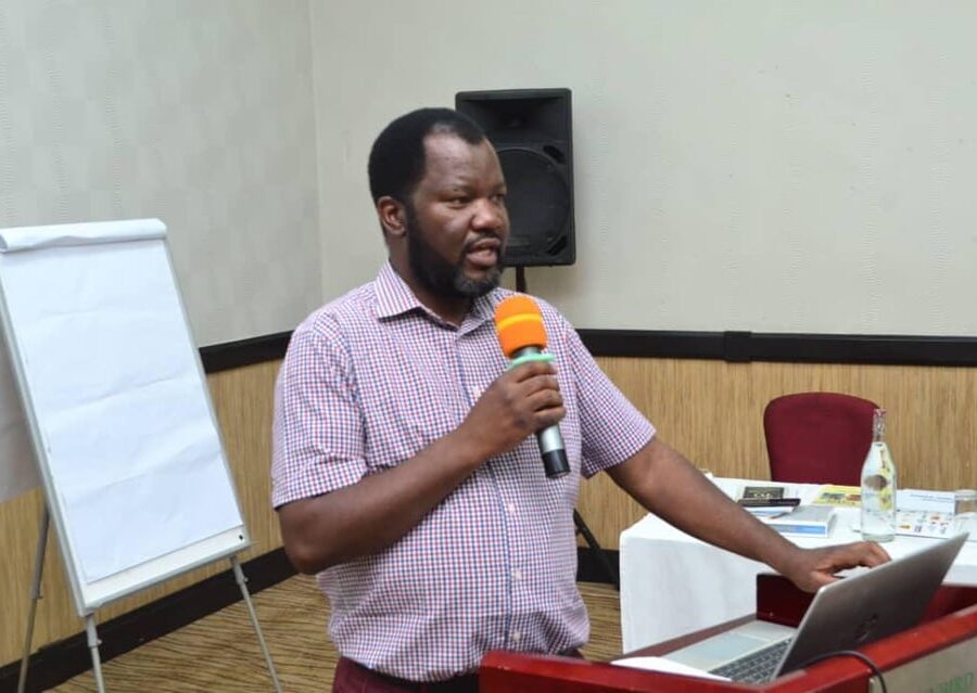 Benson Mukandiwa presenting beside a laptop and flip chart