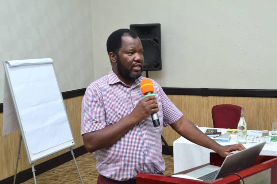 Benson Mukandiwa presenting beside a laptop and flip chart